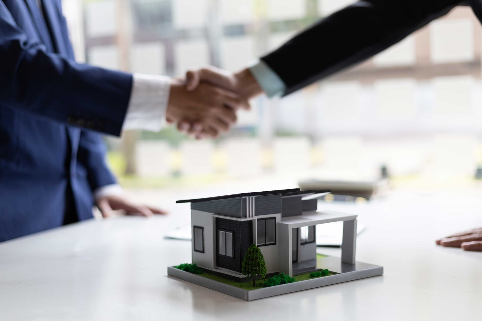 Dos personas haciendo un contrato de compraventa de una casa